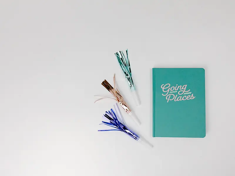 Libreta de planeación y artículos de fiesta para calcular el presupuesto de una mesa de dulces