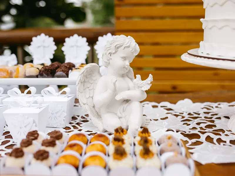 Mesa de dulces para bautizo y primera comunión con pastel blanco, angelito y postres individuales
