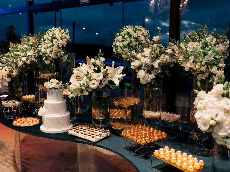 Paquete Bespoke: montaje de gran escala con pastel de pisos, cientos de postres y arreglos florales