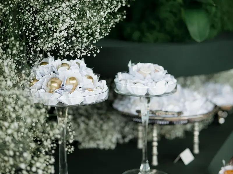 Paquete Signature: mesa de postres elegante con merengues, bases de cristal y flores blancas